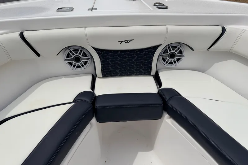 Slide: The Image of 2024 Tidewater 256 LXF boat interior with cushioned seating and built-in speakers. - 19
