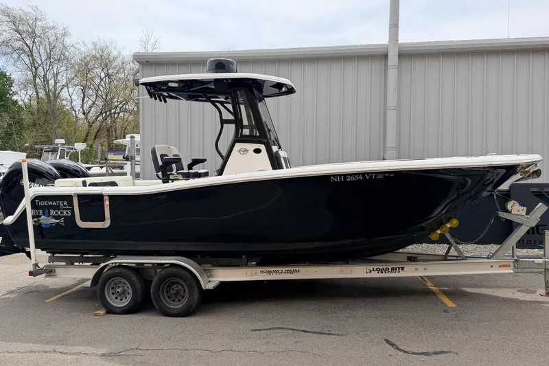 Slide: The Image of 2024 Tidewater 256 LXF boat on trailer, sleek black design, parked outdoors. - 2