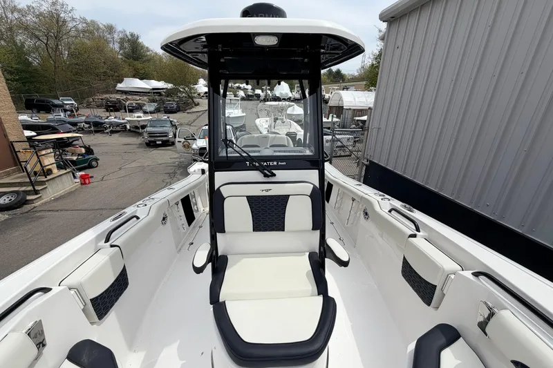 Slide: The Image of 2024 Tidewater 256 LXF boat with sleek seating and modern design in a marina setting. - 24