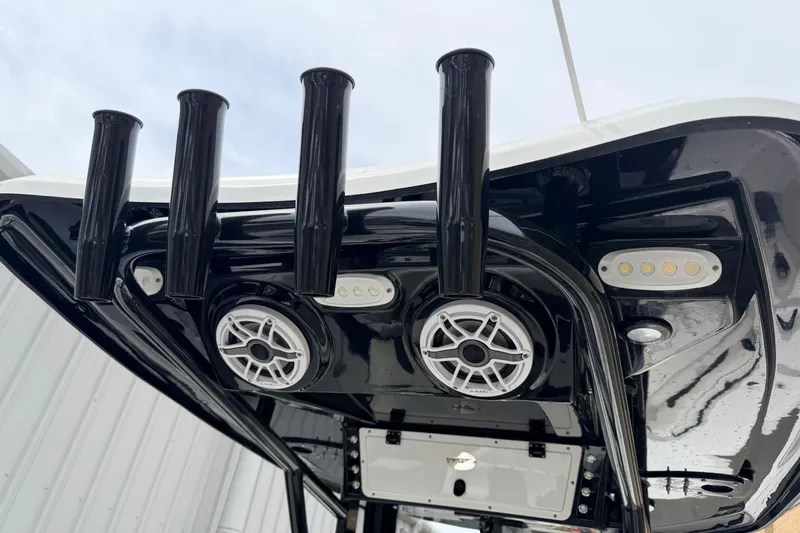 Slide: The Image of 2024 Tidewater 256 LXF boat's T-top with rod holders and speakers. - 31