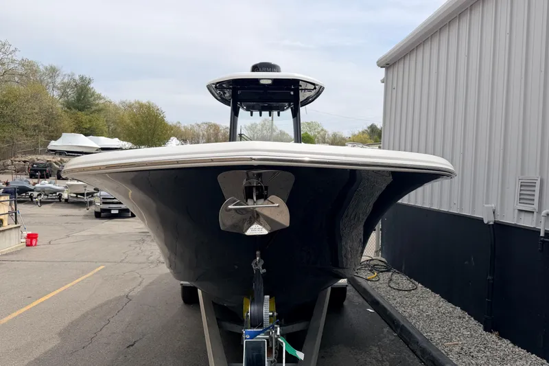 Slide: The Image of 2024 Tidewater 256 LXF boat on trailer, parked near a building. - 5