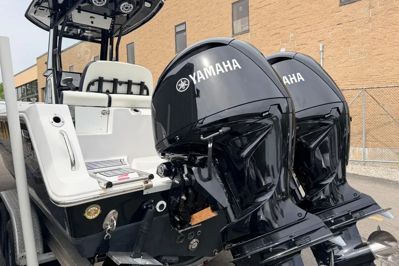 Slide: The Image of 2024 Tidewater 256 LXF boat with dual Yamaha outboard engines, parked outdoors. - 8