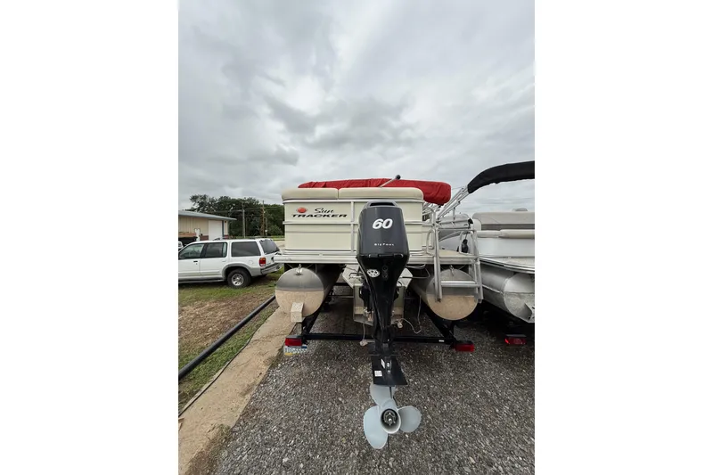 Slide: The Image of 2007 Sun Tracker Party Barge 21 Signature Series with 60 HP outboard motor, parked outdoors. - 4