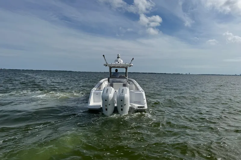 Slide: The Image of 2025 Everglades 315 Center Console boat cruising on open water under a cloudy sky. - 12