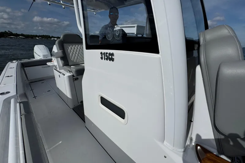 Slide: The Image of 2025 Everglades 315 Center Console boat on water, showcasing sleek design and seating. - 23