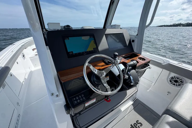 Slide: The Image of 2025 Everglades 315 Center Console boat dashboard with steering wheel and navigation screens. - 24