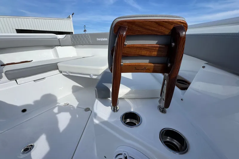 Slide: The Image of 2025 Everglades 315 Center Console boat interior with wooden seat and cup holders. - 43