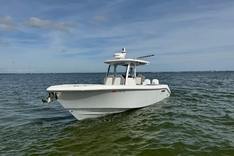 Slide: The Image of 2025 Everglades 315 Center Console boat cruising on open water under a clear sky. - 5