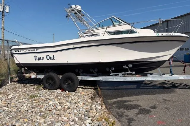 The Image of 1994 Grady-White Explorer 244 boat named "Time Out" on a trailer in a parking lot. - 0