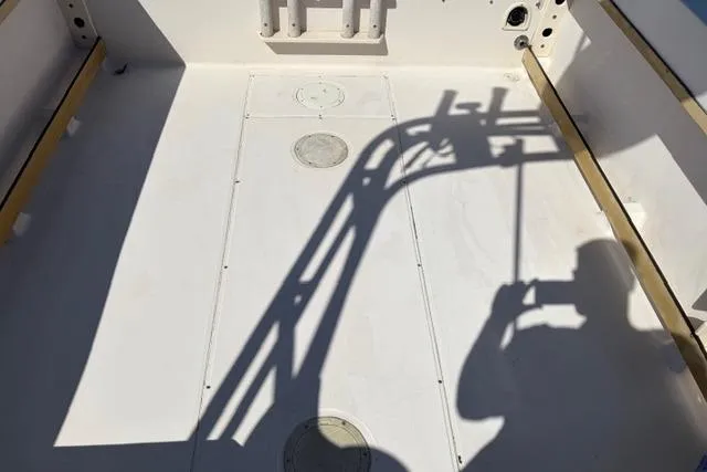 Slide: The Image of 1994 Grady-White Explorer 244 boat interior with shadows and fishing rod holders. - 2
