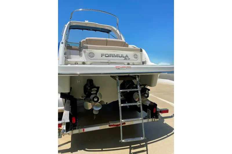 Slide: The Image of 2019 Formula 310 Bowrider boat rear view with ladder and dual propellers. - 10