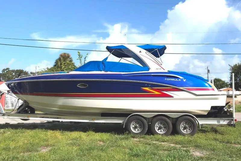 Slide: The Image of 2019 Formula 310 Bowrider boat on trailer, blue and white design, parked outdoors. - 2
