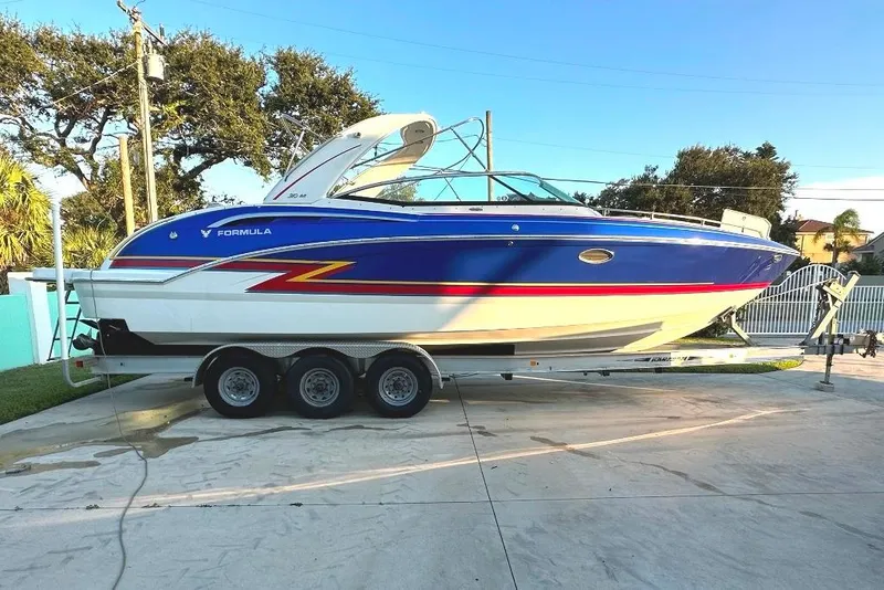 Slide: The Image of 2019 Formula 310 Bowrider boat on trailer, blue and white design, parked outdoors. - 3