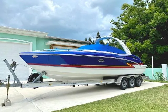 Slide: The Image of 2019 Formula 310 Bowrider boat on trailer, vibrant blue and white design, parked outdoors. - 6