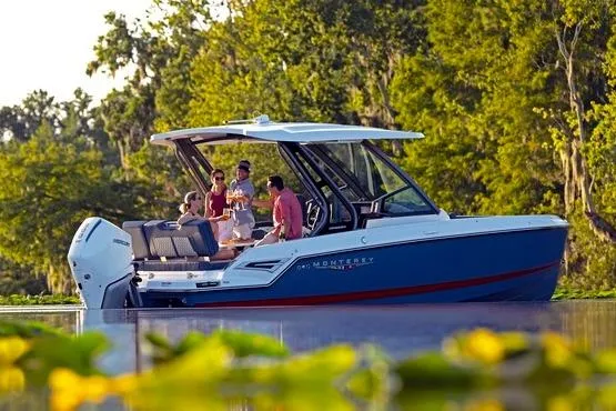Slide: The Image of 2026 Monterey Elite 25 OB boat on a serene lake with people enjoying a sunny day. - 10