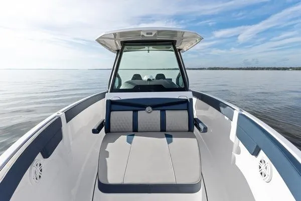 Slide: The Image of 2026 Monterey Elite 25 OB boat on calm water, featuring sleek design and spacious seating. - 7