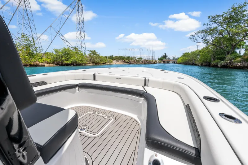 Slide: The Image of 2026 Tidewater 2500 Carolina Bay boat on scenic waterway with lush greenery. - 11
