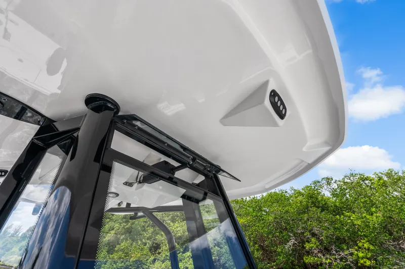 Slide: The Image of 2026 Tidewater 2500 Carolina Bay boat canopy with sleek design against blue sky. - 13