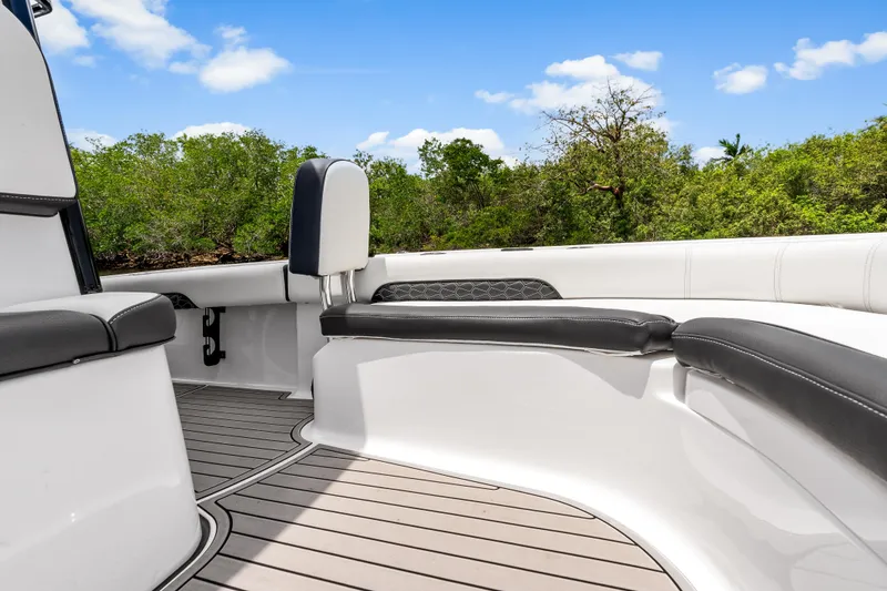Slide: The Image of 2026 Tidewater 2500 Carolina Bay boat interior with sleek seating and lush greenery backdrop. - 14