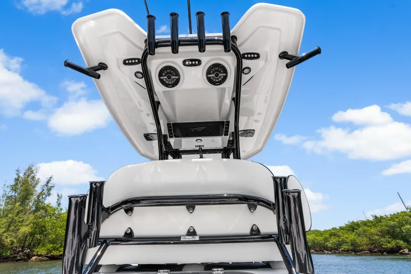 Slide: The Image of 2026 Tidewater 2500 Carolina Bay boat with T-top and rod holders against blue sky. - 19