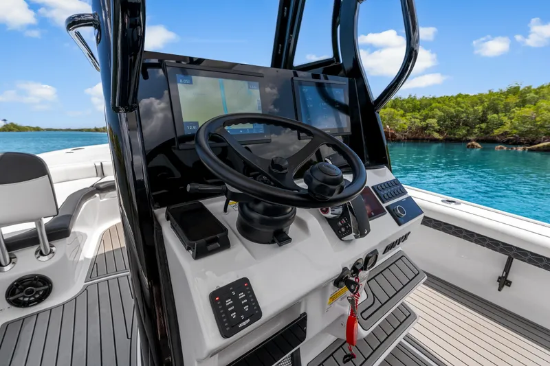 Slide: The Image of 2026 Tidewater 2500 Carolina Bay boat dashboard with steering wheel and navigation screens. - 23