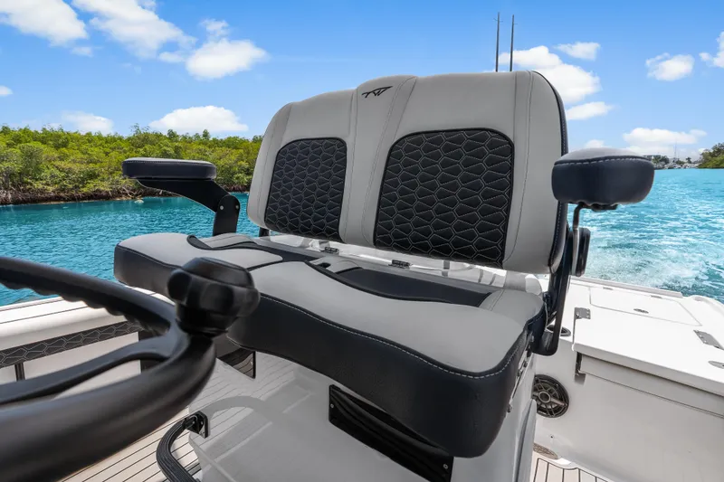 Slide: The Image of 2026 Tidewater 2500 Carolina Bay boat helm seat with scenic water backdrop. - 24