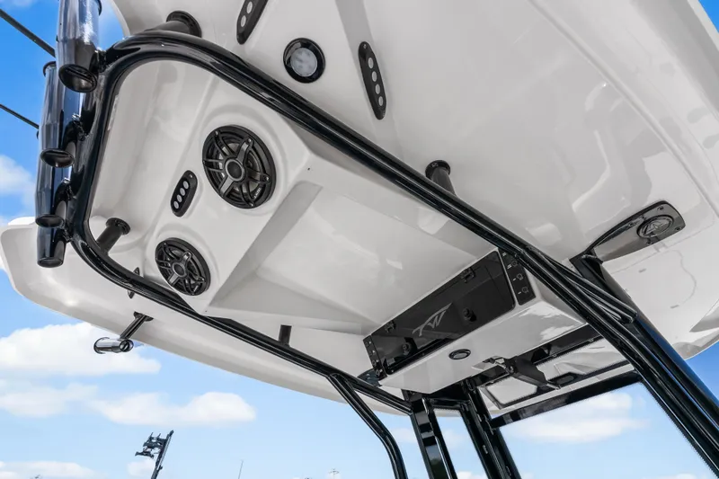 Slide: The Image of 2026 Tidewater 2500 Carolina Bay boat's T-top with speakers and rod holders against blue sky. - 27