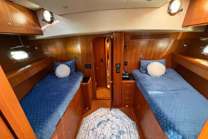 Slide: The Image of Luxurious 2016 Nordhavn 52 yacht cabin with twin beds and elegant wood paneling. - 14