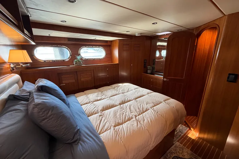 Slide: The Image of Luxurious 2016 Nordhavn 52 yacht bedroom with wood paneling and cozy bedding. - 18