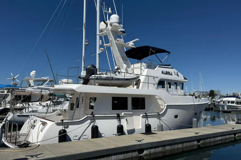 Slide: The Image of 2016 Nordhavn 52 yacht docked at marina under clear blue sky. - 6