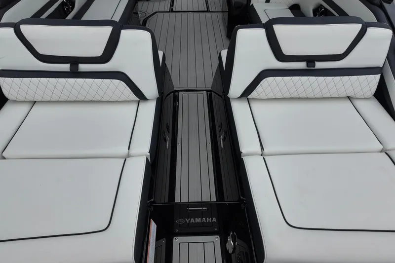 Slide: The Image of 2025 Yamaha 275 SD boat interior with white cushioned seating and sleek design. - 10