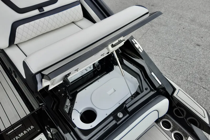 Slide: The Image of 2025 Yamaha 275 SD boat storage compartment with open hatch and cushioned seating. - 11