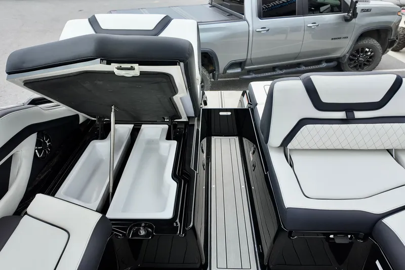 Slide: The Image of 2025 Yamaha 275 SD boat interior with open storage compartments and luxury seating. - 13