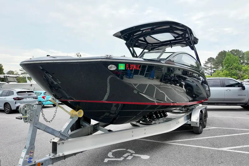 Slide: The Image of 2025 Yamaha 275 SD boat on trailer in parking lot, sleek black design. - 3