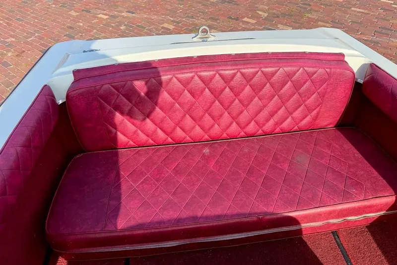 Slide: The Image of 1981 SKI NAUTIQUE boat with red quilted leather seating on a brick surface. - 18