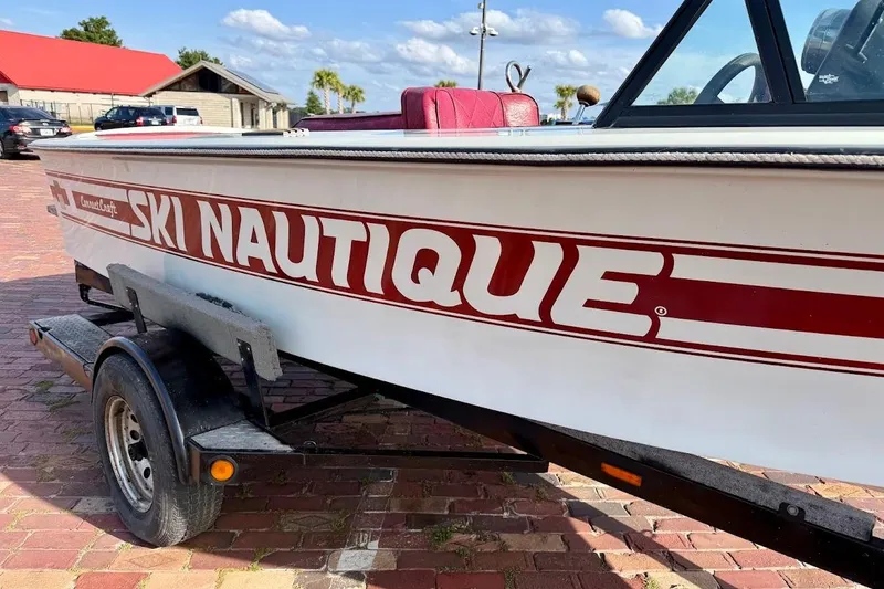 Slide: The Image of 1981 SKI NAUTIQUE boat on trailer, red and white design, sunny day background. - 9