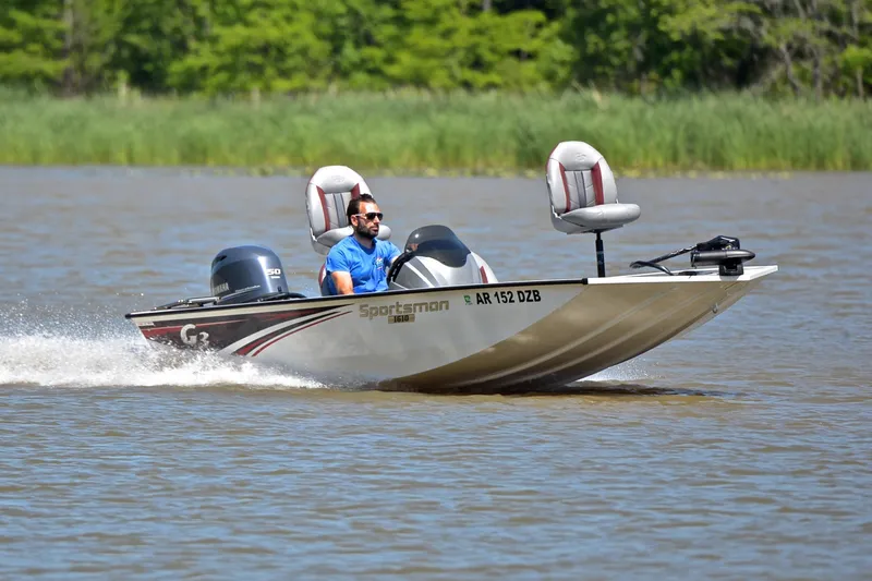 The Image of 2023 G3 Sportsman 1610 boat cruising on a lake with lush green background. - 1