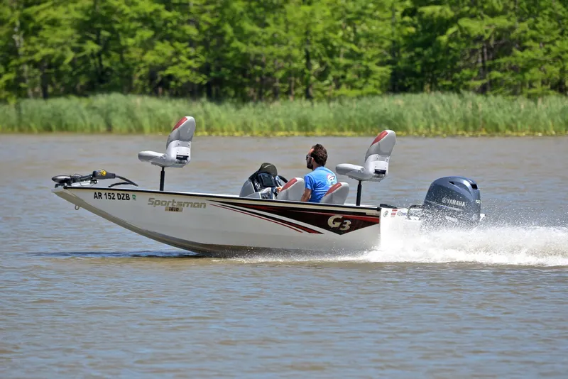 Slide: The Image of 2023 G3 Sportsman 1610 boat cruising on a lake with lush green background. - 4