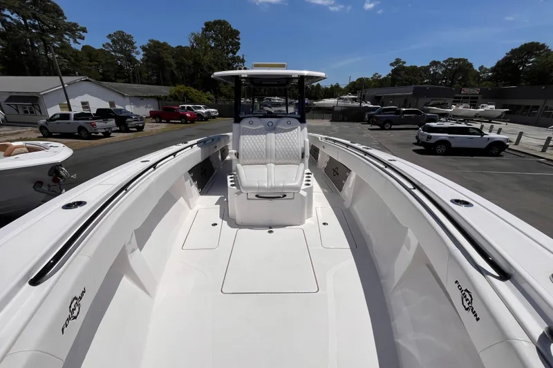 Slide: The Image of 2025 Fountain 38 Tournament Edition boat interior with seating, docked outdoors. - 12