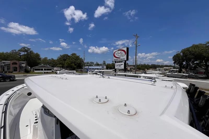 Slide: The Image of 2025 Fountain 38 Tournament Edition boat on display at a marine dealership under a clear blue sky. - 18