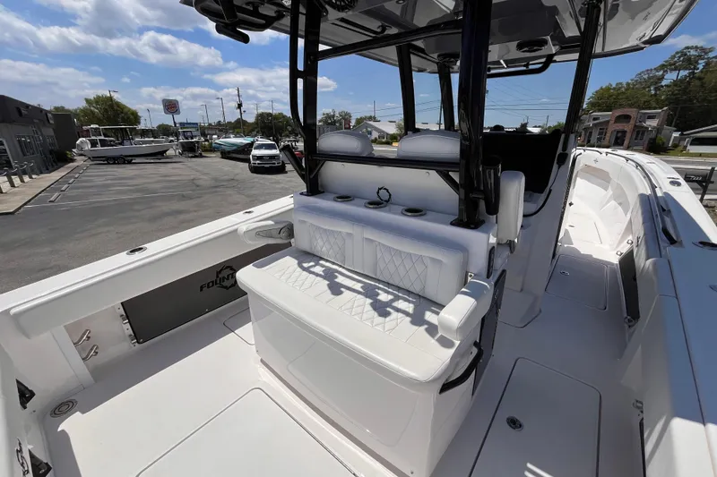 Slide: The Image of 2025 Fountain 38 Tournament Edition boat interior with seating and console, parked outdoors. - 7