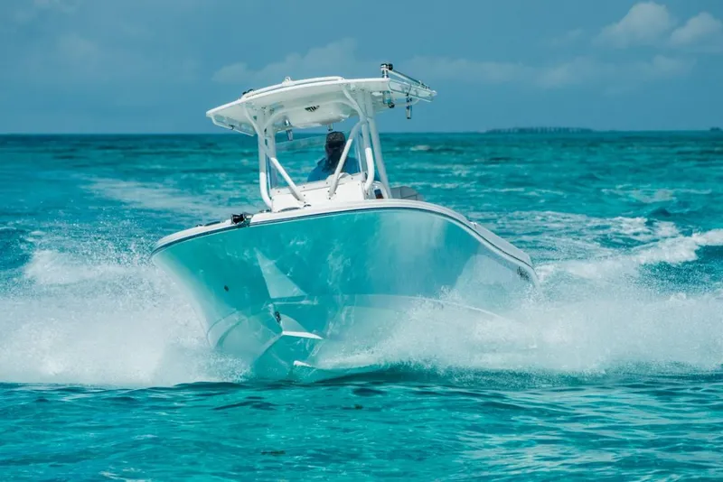 The Image of 2025 Edgewater 245CC boat cruising on clear turquoise water. - 0