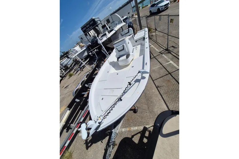 Slide: The Image of 2018 Boca Bay 224 Bay boat on trailer, parked in marina under clear sky. - 3