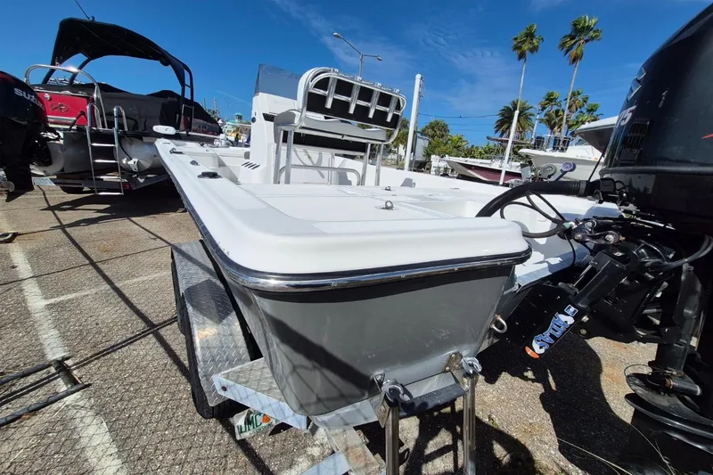Slide: The Image of 2018 Boca Bay 224 Bay boat on trailer, parked outdoors under clear blue sky. - 5
