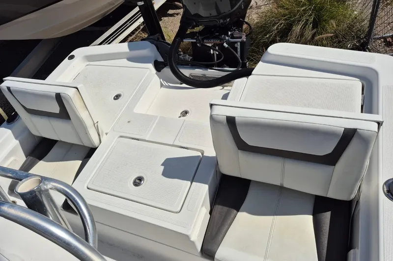 Slide: The Image of 2018 Boca Bay 224 Bay boat interior with white seating and storage compartments. - 9