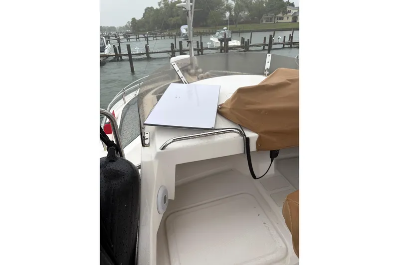 Slide: The Image of 2024 Ranger Tugs R-29 CB boat interior with covered equipment and dock view. - 13