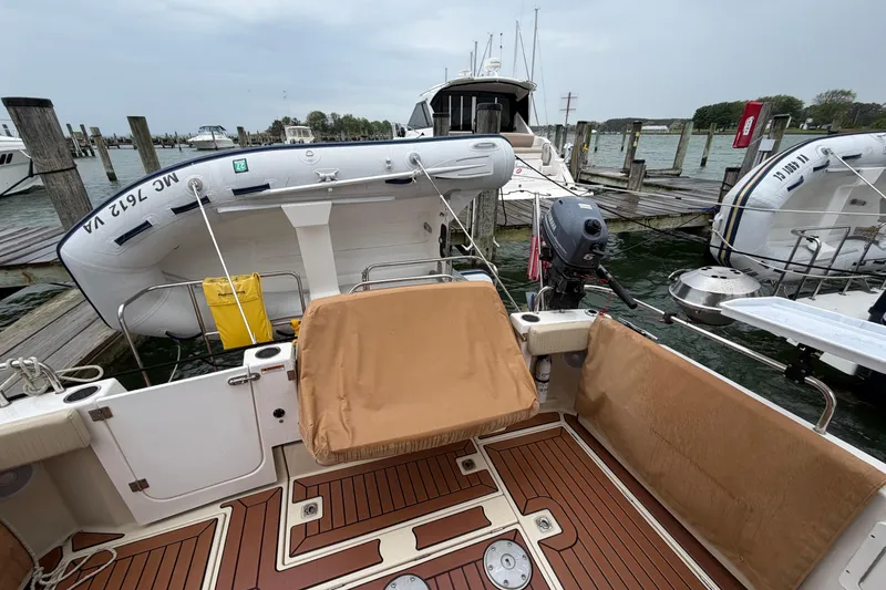 Slide: The Image of 2024 Ranger Tugs R-29 CB boat docked with inflatable dinghy and outboard motor. - 2
