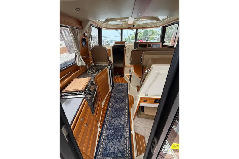 Slide: The Image of 2024 Ranger Tugs R-29 CB interior with modern kitchen and seating area. - 3