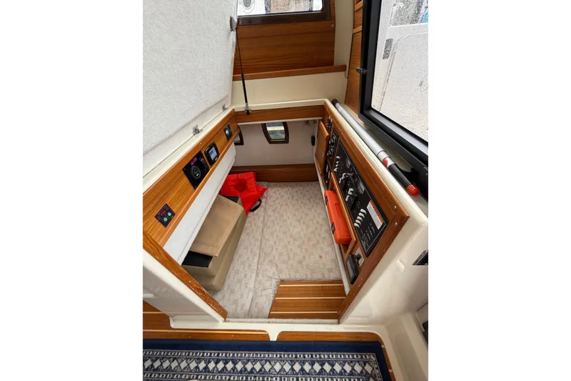 Slide: The Image of 2024 Ranger Tugs R-29 CB cabin interior with control panels and seating area. - 5