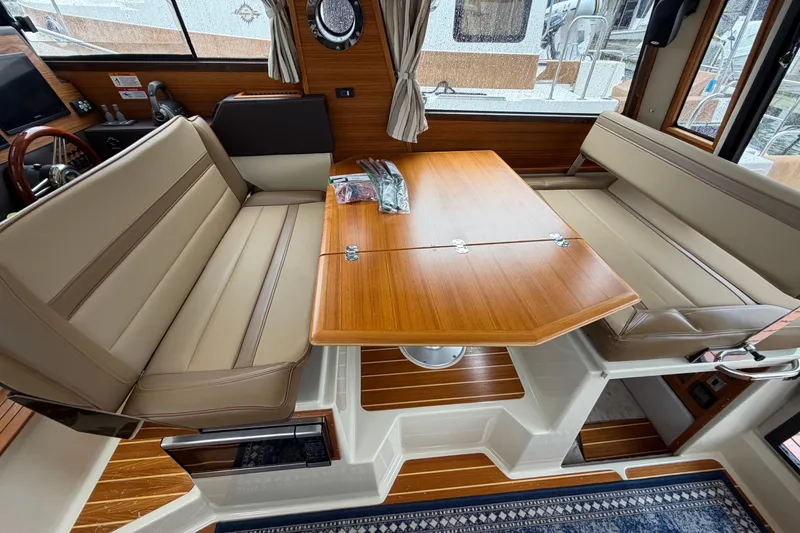 Slide: The Image of 2024 Ranger Tugs R-29 CB interior with elegant seating and wooden table. - 6